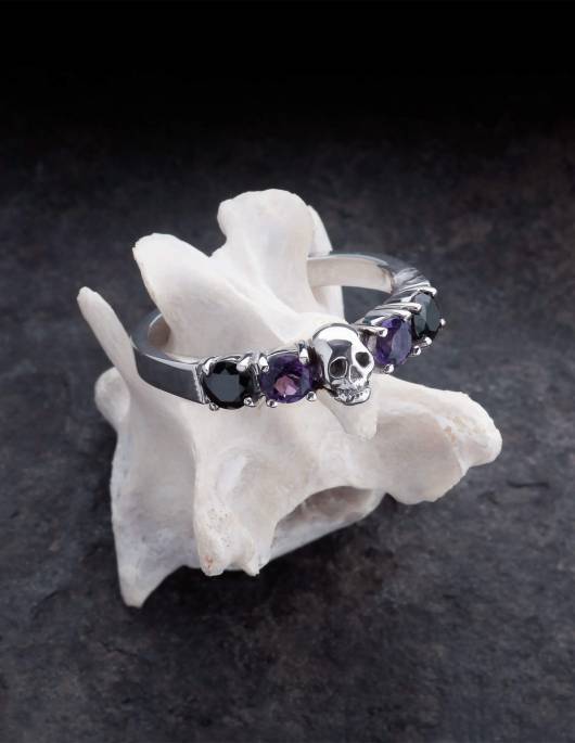 Helice is a magnificent wedding ring with a skull surrounded by four round gemstones. The ring is made of silver by the goldsmith Kipkalinka. The ring rests on a bone.