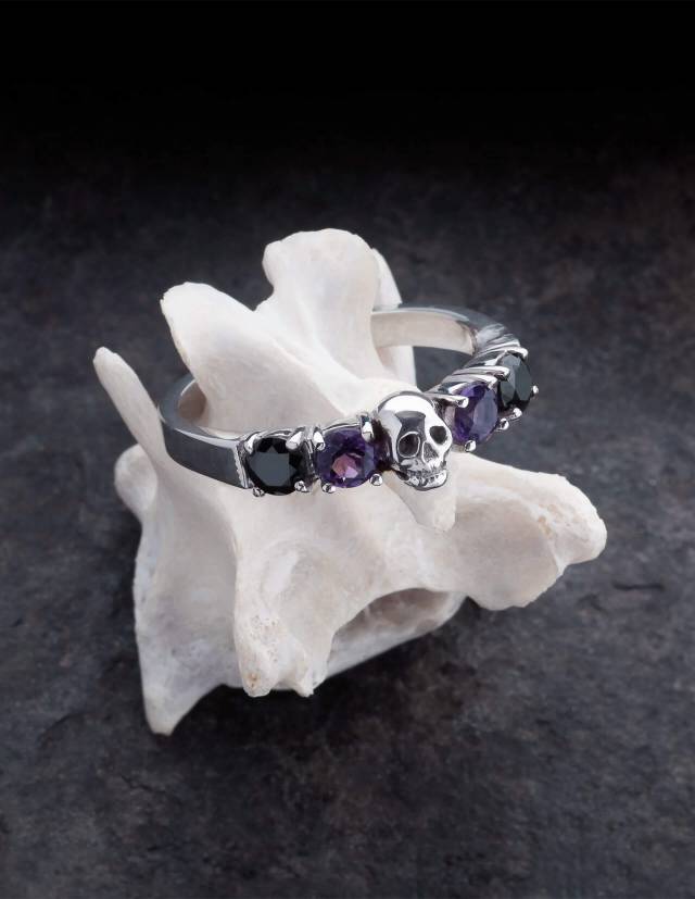 Helice is a magnificent wedding ring with a skull surrounded by four round gemstones. The ring is made of silver by the goldsmith Kipkalinka. The ring rests on a bone.