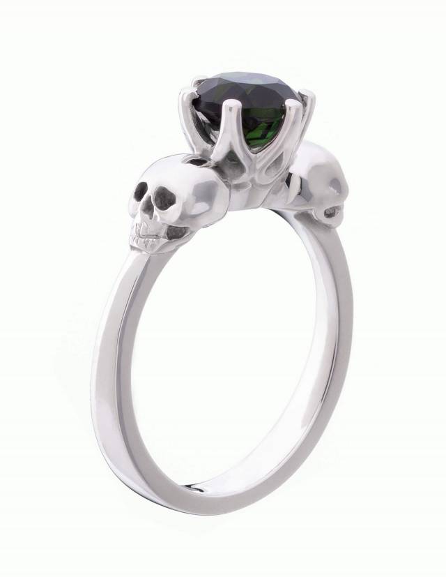 Wandika is a delicate women's silver skull ring. It features a small black gemstone in a delicate setting. Side view.