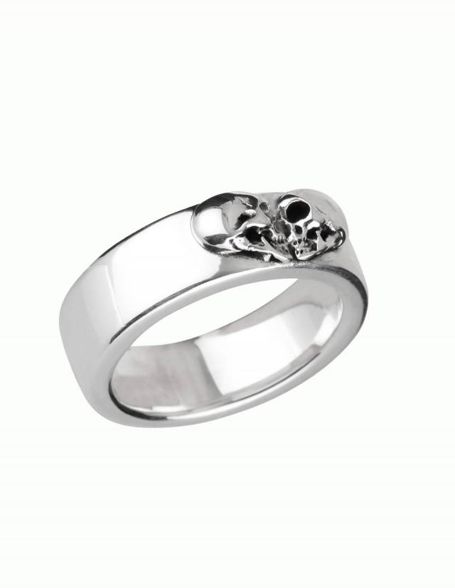 Kissing Skulls es un anillo gótico de plata maciza. Dos cráneos de perfil están dispuestos en forma de corazón. La forma del anillo es ancha y ligeramente plana con bordes redondeados. Representación lateral.