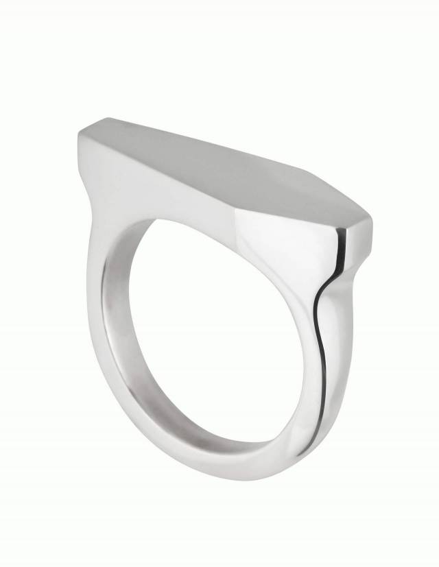 Necromance ist ein Siegelring in Form eines Sarges aus 925er Silber. Das Design ist sehr massiv, schlicht und elegant. Die Oberfläche des Ringes ist glatt und glänzend. Die Ringschiene ist angenehm gerundet und hat einen Verlauf. Foto leicht seitlich.