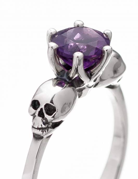 A small skull ring for women made of silver with amethyst.