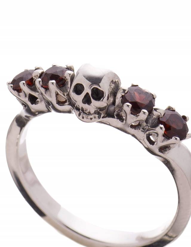 Ein zarter Edelsteinring mit einem kleinen Totenkopf und 4 roten Granat Edelsteinen. Der Ring heißt Ctyrka.