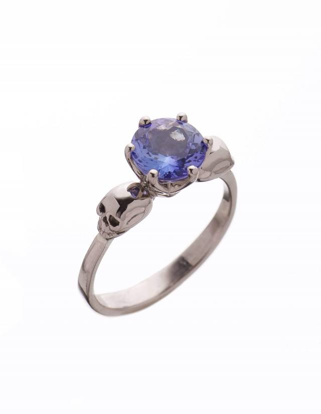 Un prezioso anello a forma di teschio in oro bianco con una gemma di tanzanite vista dall'alto.