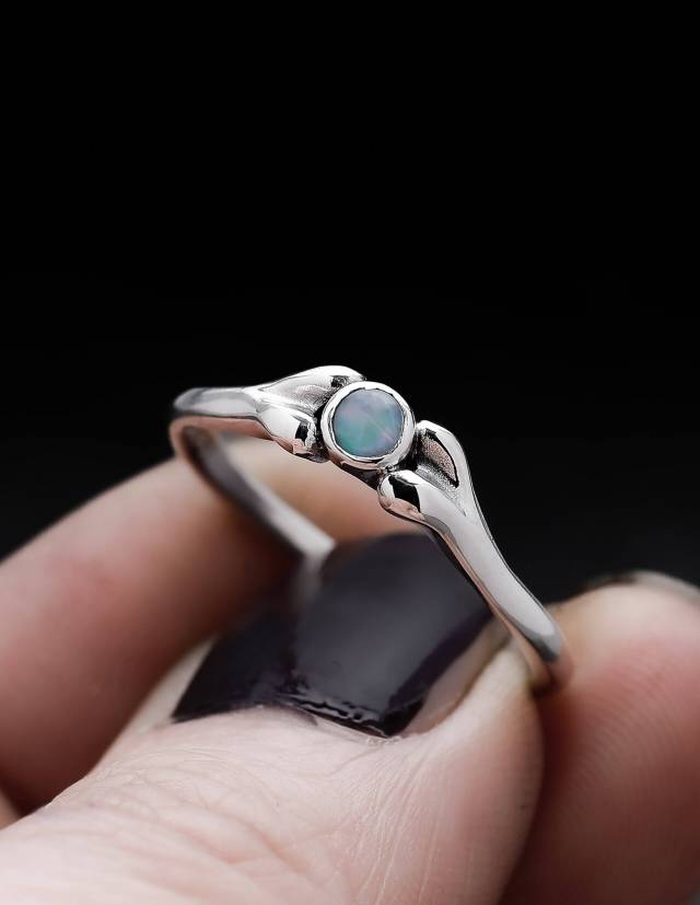 Ein kleiner Opal RIng in Form eines Knochens.