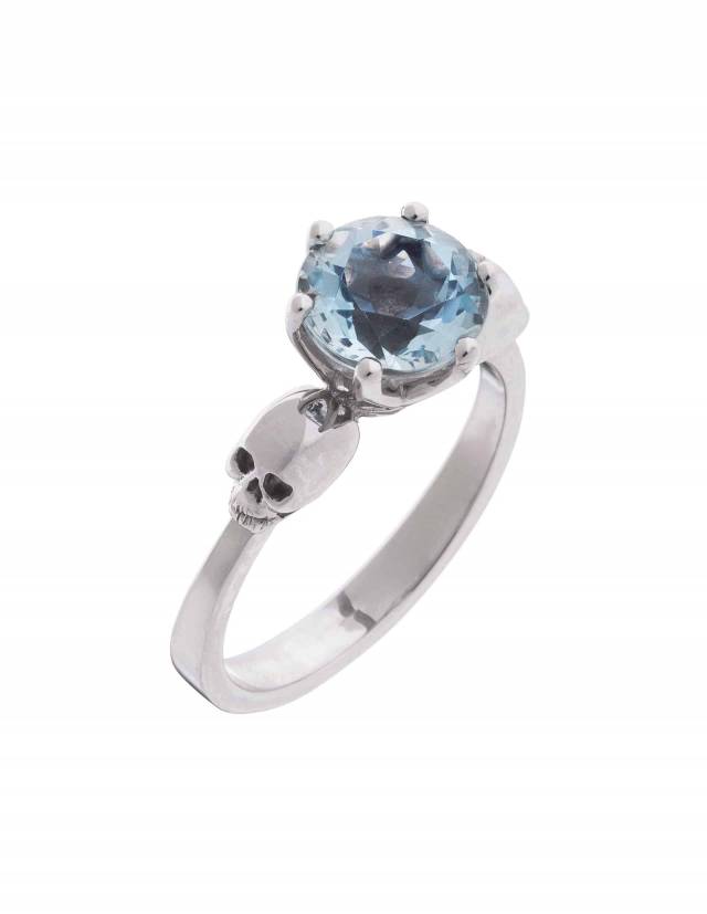 Anillo gótico de dos calaveras con gema de topacio azul claro visto desde arriba.