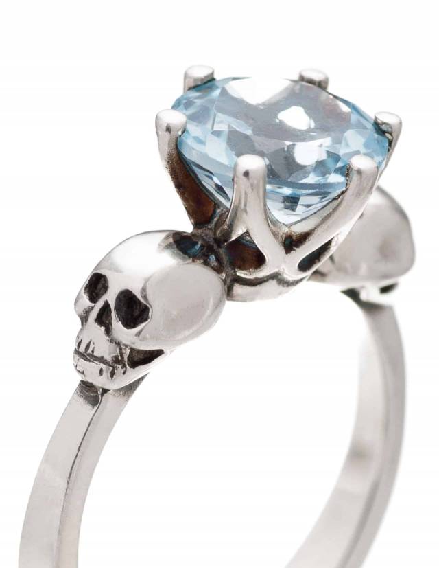 Anillo gótico de dos calaveras con gema de topacio azul claro.