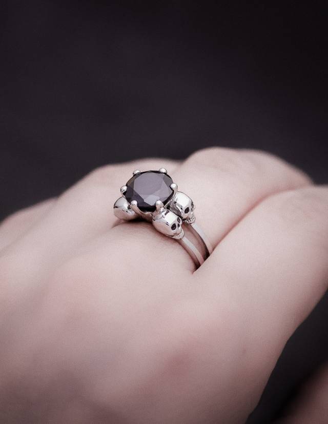A detailed skullring for women with black moissanite gemstone, the ring is made of sterling silver and carries the name VARLA.