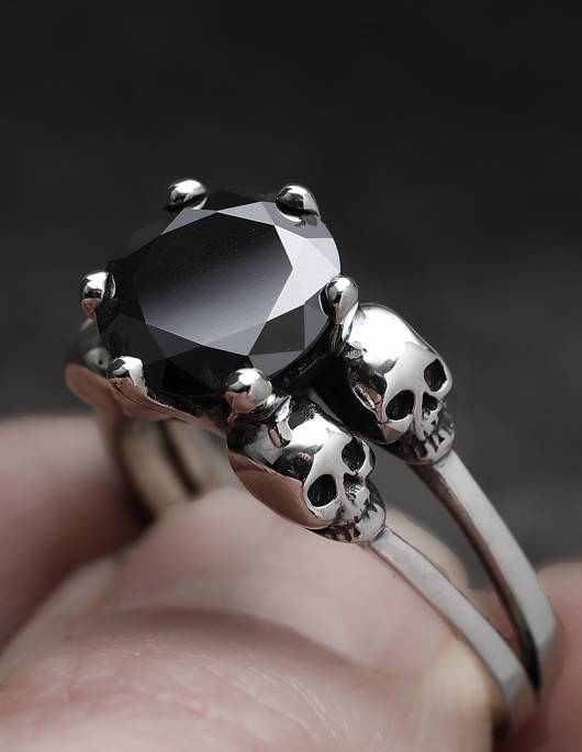 Ein Skullring für Frauen mit kleinen Totenköpfen und einem schwarzen Edelstein, Modell VARLA von Kipkalinka