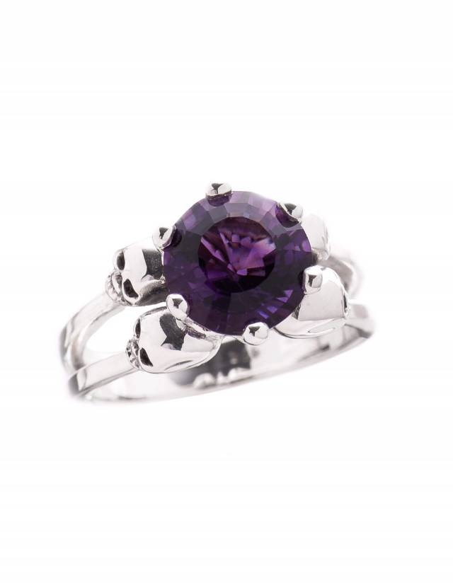 A goth ring made of sterling silver with little skulls and a stunning deep purple amethyst gemstone.