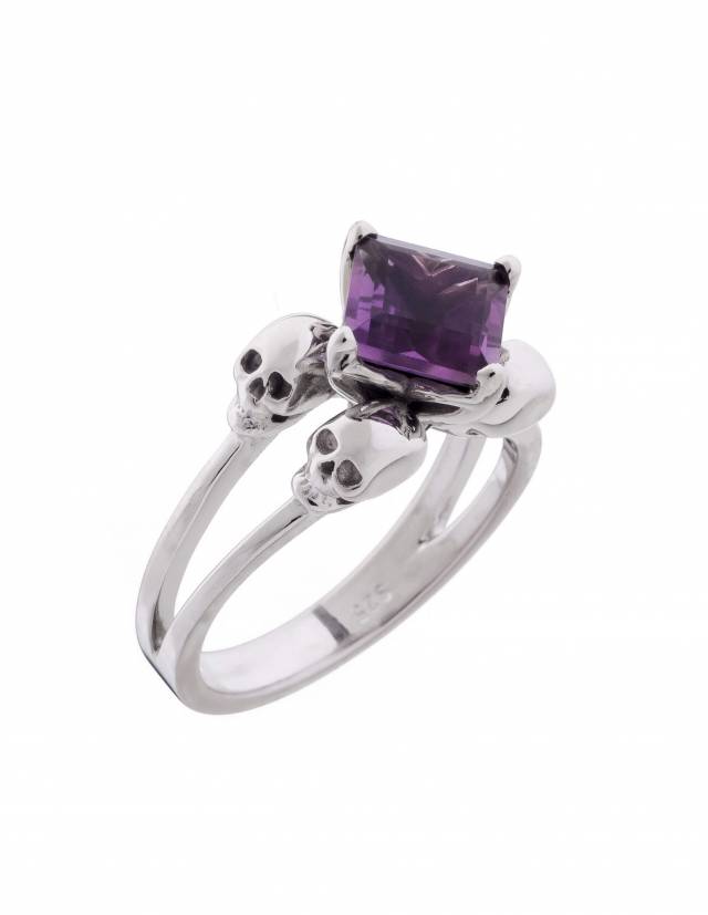 A filigree ring made of silver with small skulls and amethyst gemstone.