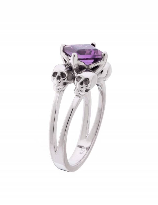 A silver engagement ring with 4 skulls for women with amethyst gemstone.