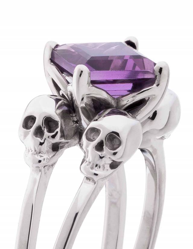 A silver engagement ring with 4 skulls for women with amethyst gemstone.