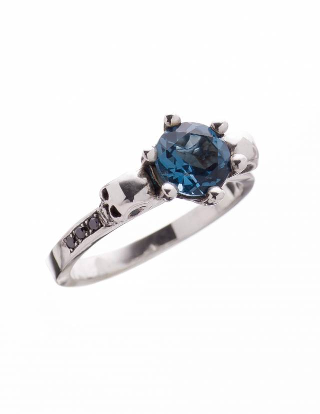 Bague crâne classique pour femme avec gemme bleue et petits diaomnds.