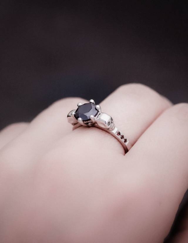 Dainty skull ring with small diamonds worn.