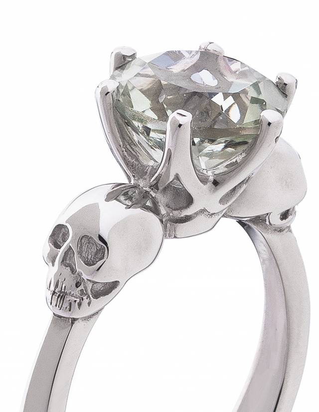 Un dettagliato anello a forma di teschio in argento sterling, chiamato WANDA, con una gemma ametista verde incastonata.