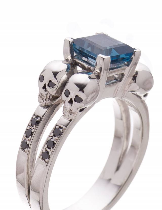 Womens 4 skull engagement ring with black diamonds and blue topaz gemstones.
