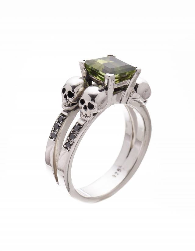 Skull ring made of sterling silver with green peridot gemstone and black diamonds.