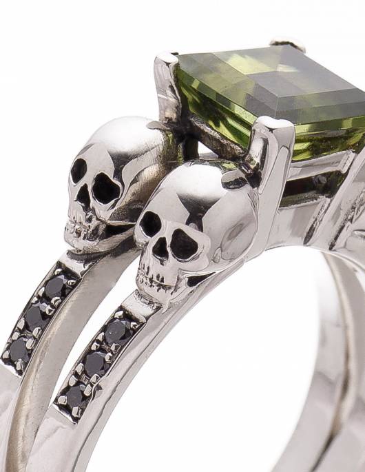 Precioso anillo de 4 calaveras para mujer con gema peridoto verde y diamantes negros, detalle de las calaveras.