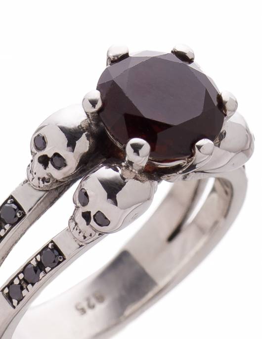 A detailed gothic engagement rign with skulls in close up. The ring is named Lilith.