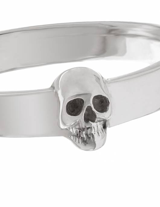 A slim and simple goth wedding band with a tiny skull made of sterling silver.
