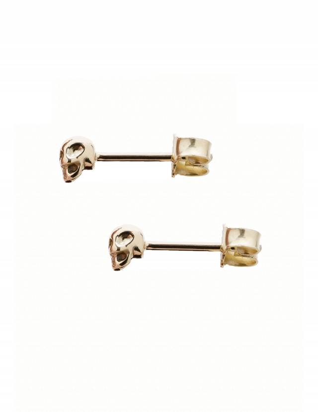 Skull earstuds made of solid 14k gold, shown from the side.